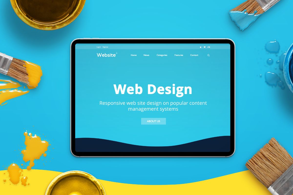 Webdesign HelpBEE Tablet mit dem Wort Web design und Pinseln und Farbe drumherum